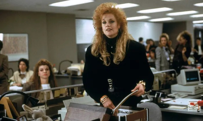 Tess McGill (portrayed by a big 80's haired Melanie Griffith) packing a brown banker's box with her office items and papers leaving her office and her job.