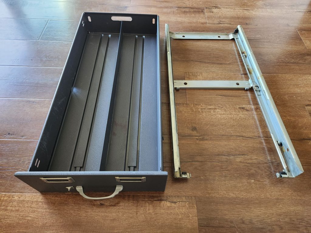 Angle on a Steelcase card index drawer and chassis. The back of the drawer features a hole just large enough to put one's hand through to make carrying the drawer as a tray easier.