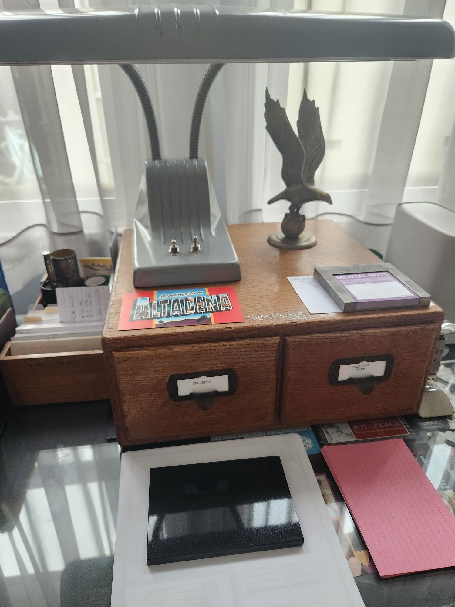 A black granite "index card" sits on a desk in front of a two drawer Shaw-Walker card index.