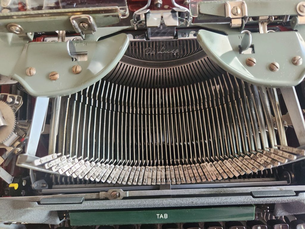With the hood removed we see into the basket of a 1956 Olympia SG1 typewriter