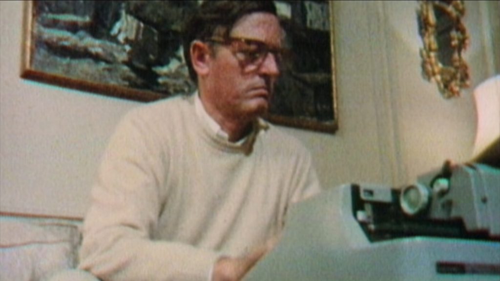 Bill Buckley typing on a Hermes 3000 typewriter at the end of a line.