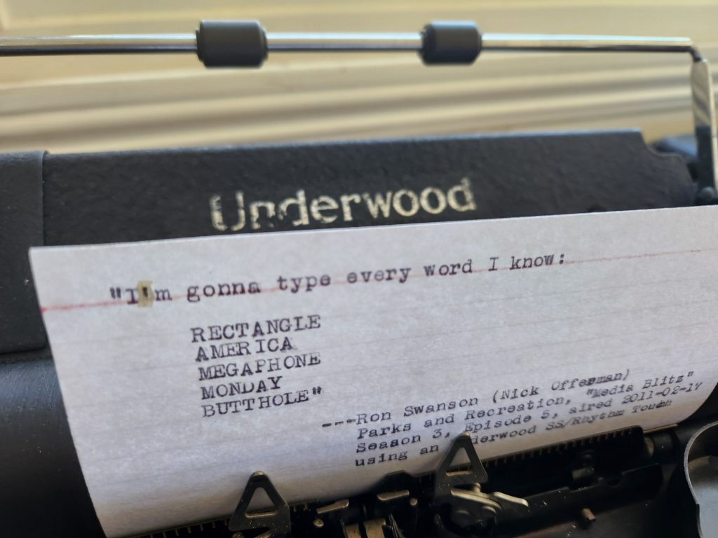 Index card in the carriage of a black Underwood SS Rhythm Touch typewriter that reads: "I'm gonna type every word I know: RECTANGLE, AMERICA, MEGAPHONE, MONDAY, BUTTHOLE" —Ron Swanson (Nick Offerman), Parks and Recreation "Media Blitz", Season 3, Episode 5, aired 2011-02-17 using an Underwood SS/Rhythm Touch