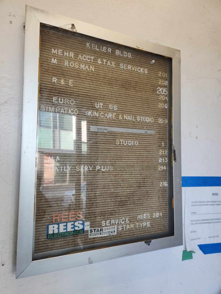 Metal case with the business directory of an office building. Rees Electronics/Star Typewriter appears at the bottom.